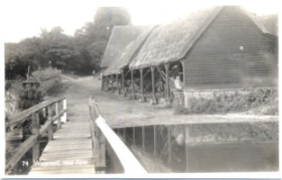 An early postcard of one of the barns by a ford over the River Lea .